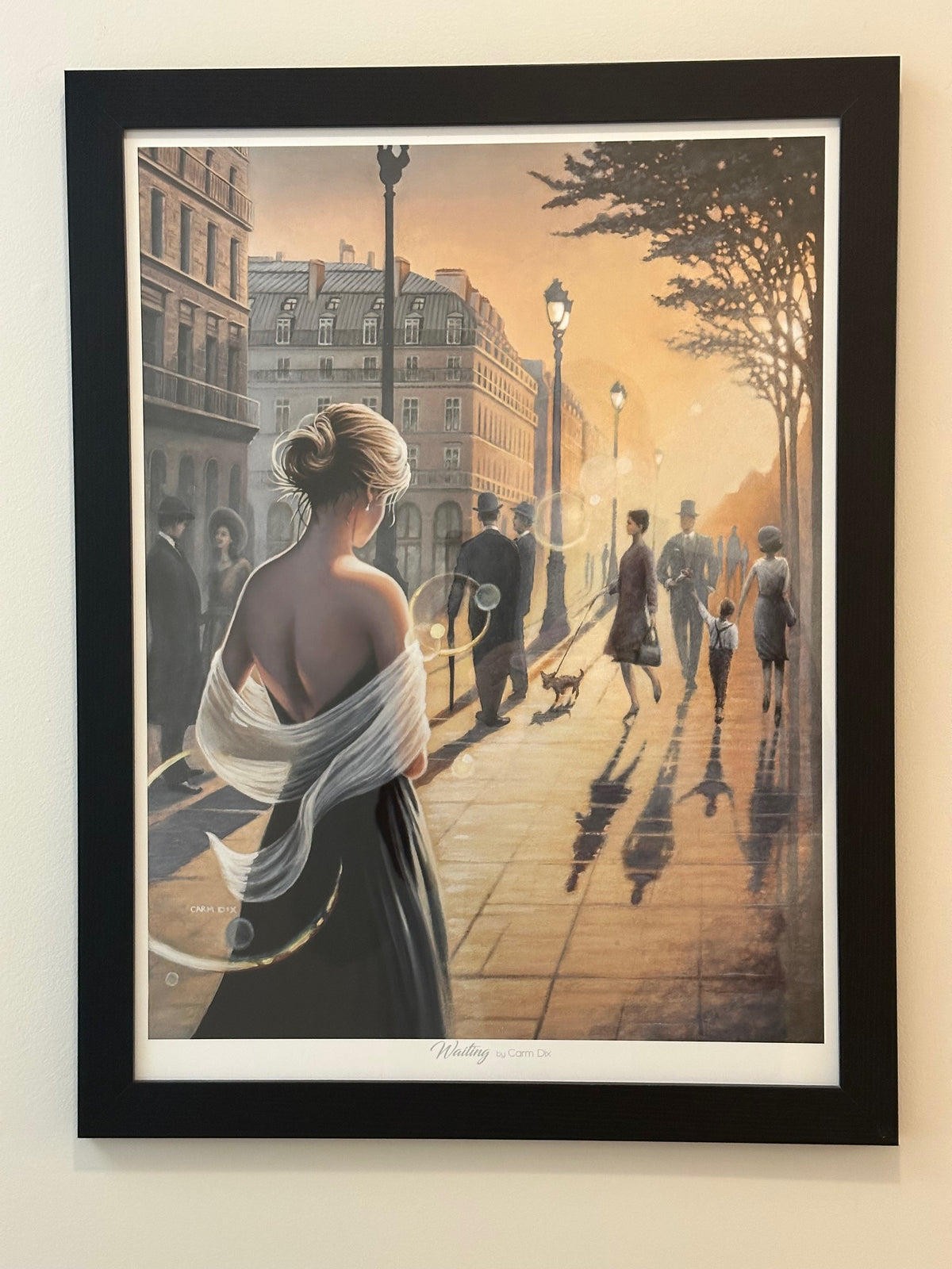 Framed artwork of a woman in a city street with a black frame.